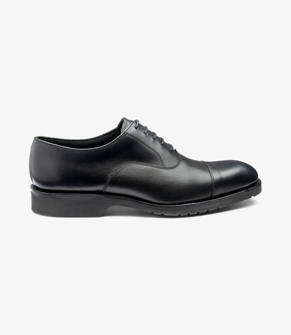 A sleek side profile of the Hitchcock shoe, highlighting the smooth black calf leather upper and defined toe-cap. The Everlight rubber sole is subtly visible, offering a hint of its practicality without compromising elegance.