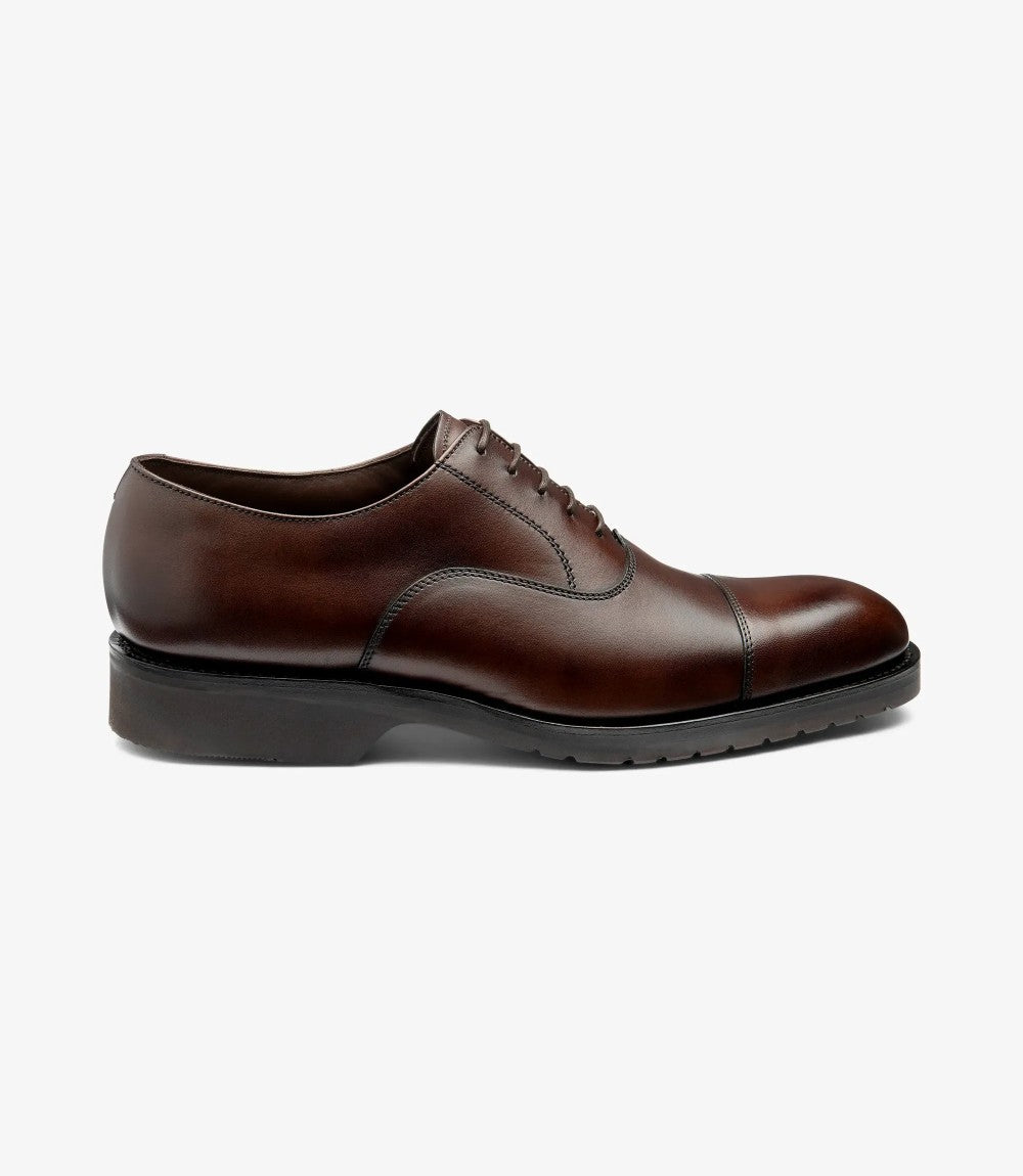 A clear profile shot of the Hitchcock Oxford showcasing the smooth dark brown leather, stitched toe cap, and sleek silhouette set atop the rubber Everlight sole.