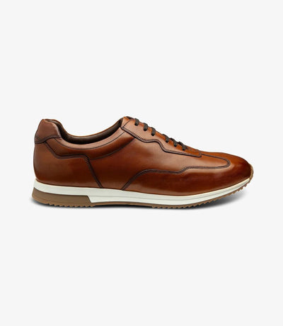 A side view showcasing the sleek silhouette of the Loake Linford Chestnut Leather Trainer, highlighting its premium calf leather construction and classic design.