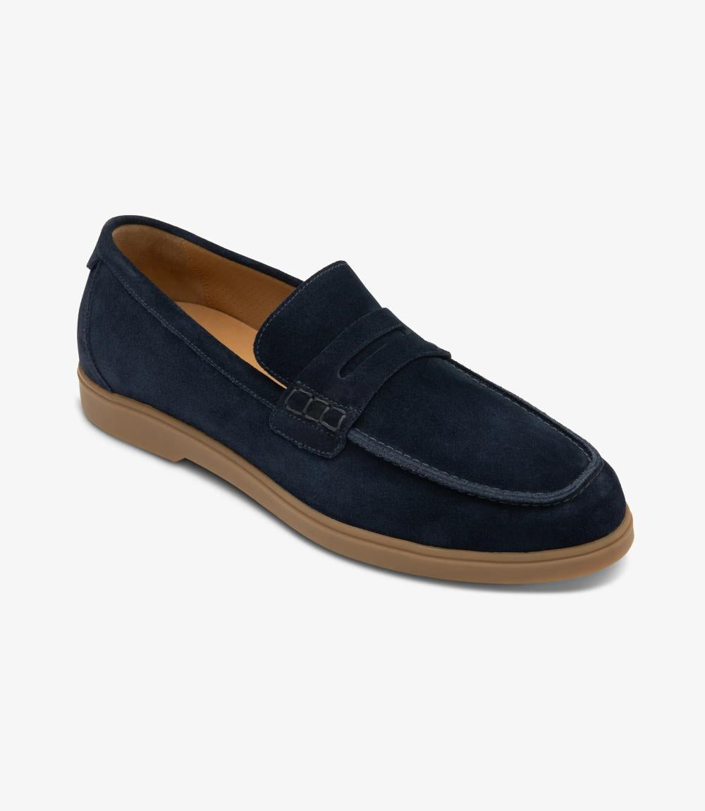 An angled shot highlighting the elegant contours and craftsmanship of the Loake Lucca Navy Suede Loafer. The supple suede material gleams under the light, while the rounded toe shape offers a comfortable fit.