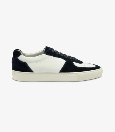 A sleek white sneaker with navy accents, crafted from premium calf leather and suede. The shoe features a rounded toe and side-stitch cup rubber soles, highlighting its elegant design and durable construction.