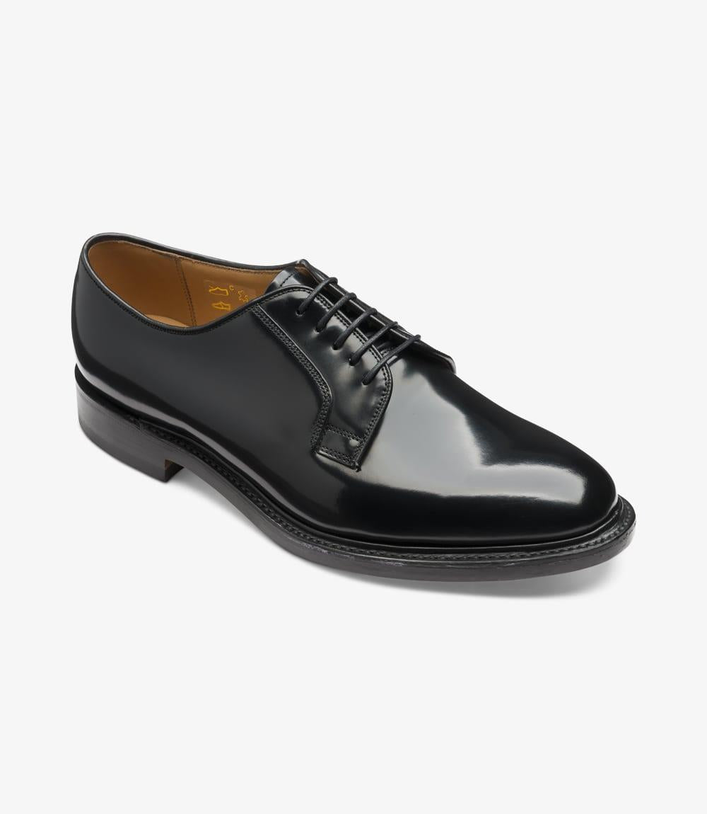 An angled view captures the Loake 771 from a slight front side perspective, showcasing the rounded toe and subtly contoured heel. The gloss of the leather is noticeable, as are the precise stitching details along the welt, lending the shoe an elegant, sophisticated look.