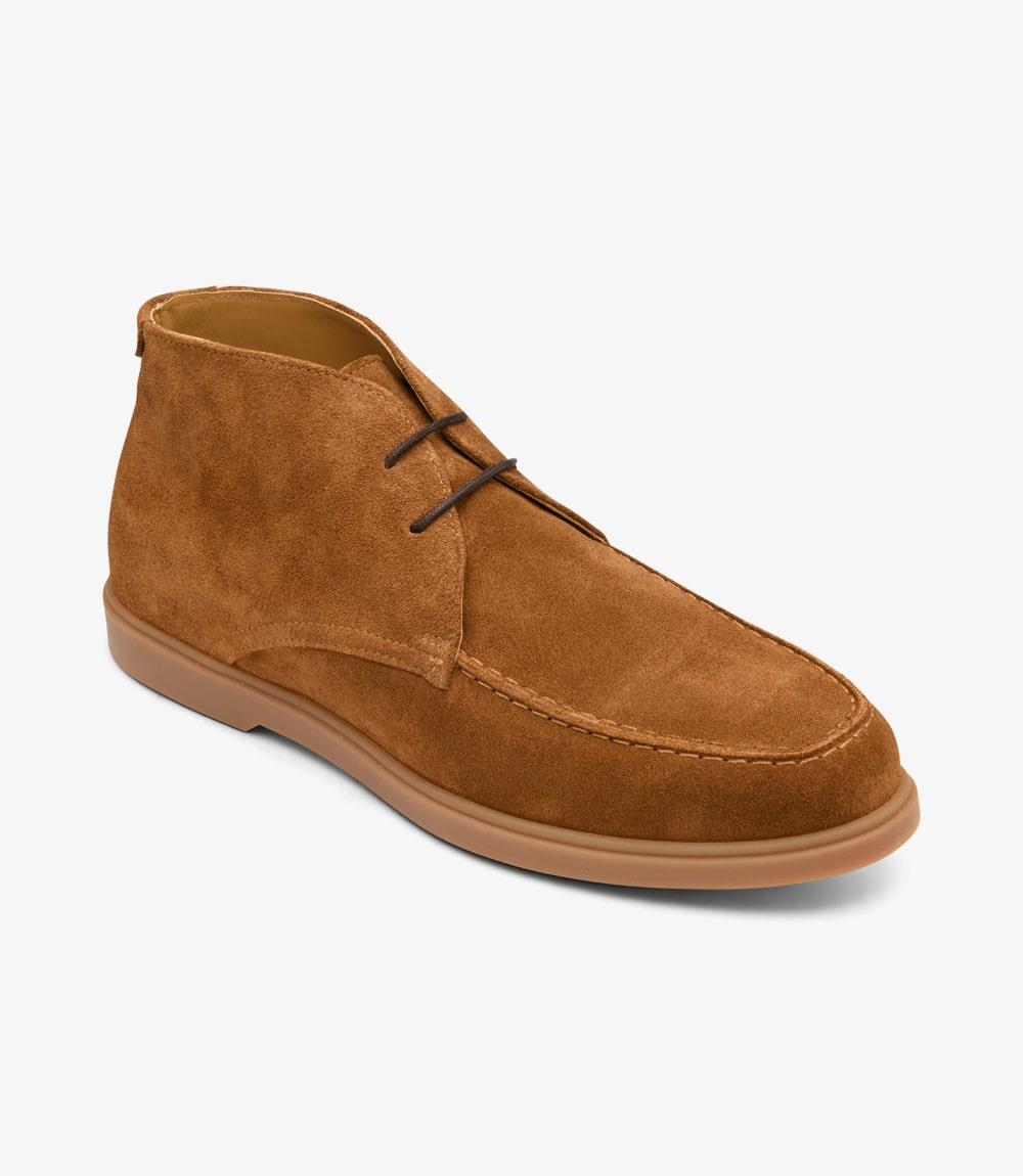  From a dynamic angle, the Chukka Boots reveal their refined craftsmanship and modern design. The rich chestnut suede shines under the light, while the rubber soles provide traction and stability, highlighting the boots' stylish profile.