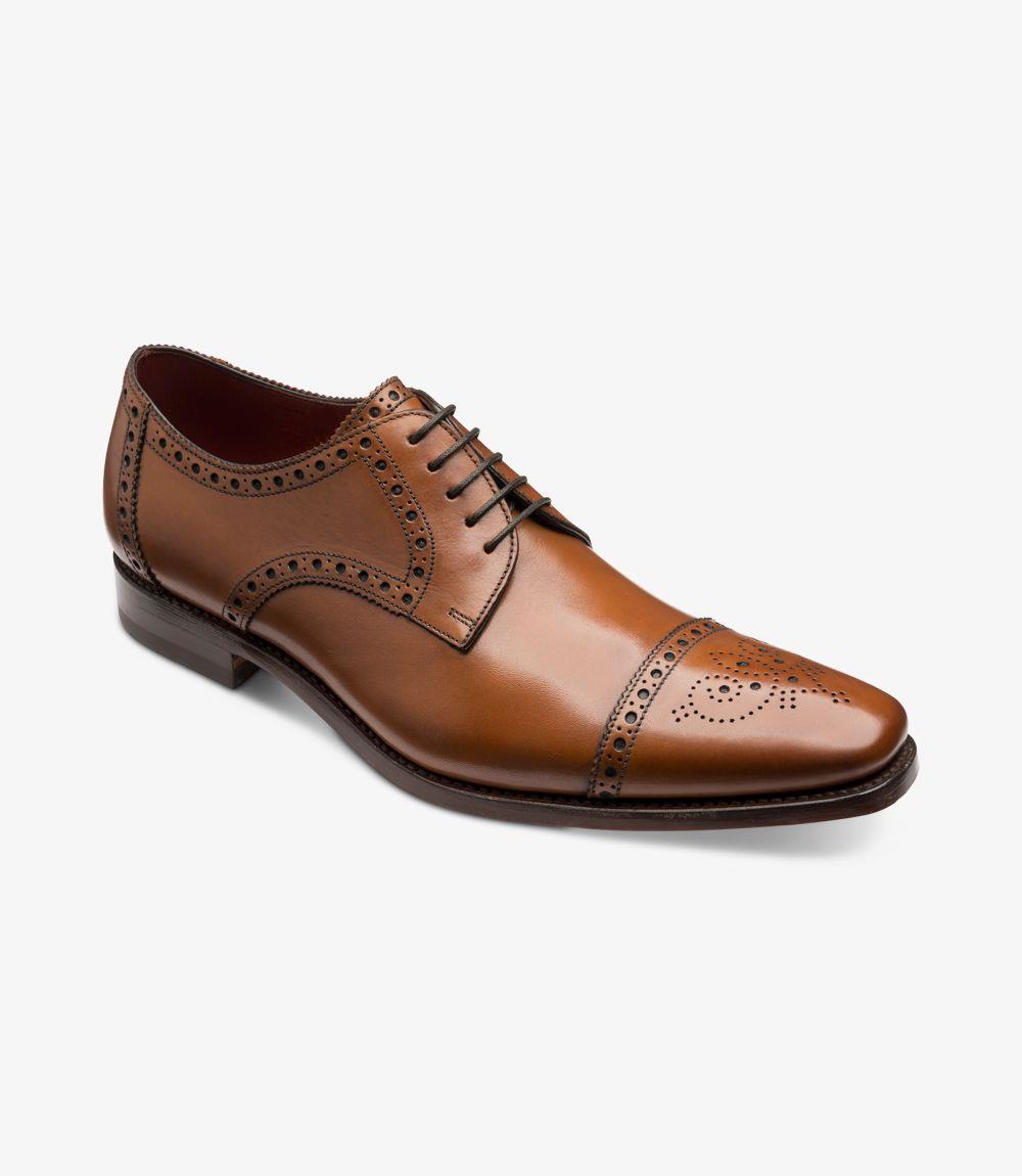 This angle highlights the shoe's unique 'Ridge' last shape, revealing the elongated toe and squared-off finish that adds character to its design. The semi-brogue detailing around the toe and wing-cap is elegantly displayed, along with the seamless transition from the upper leather to the sturdy rubber sole. The shoe's profile conveys both classic charm and contemporary style.