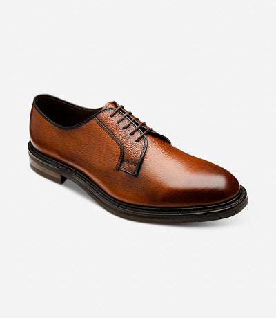 An angled shot capturing the dynamic lines and contours of the Loake Leyburn Mahogany Derby Toe Cap shoes. The rich mahogany grain calf leather and intricate detailing are highlighted from this perspective, emphasizing the timeless elegance of these shoes.
