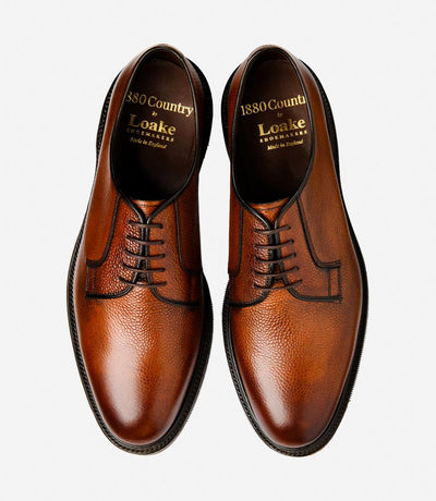 A top-down view of two Loake Leyburn Mahogany Derby Toe Cap shoes, perfectly symmetrical in design and craftsmanship. The hand-painted leather and classic derby styling are evident, reflecting the quality and attention to detail in each pair.
