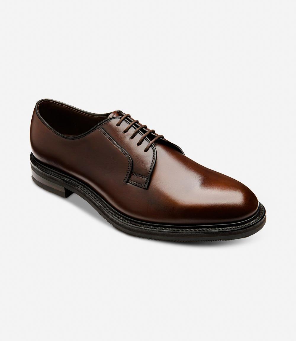 An angled shot capturing the dynamic lines and contours of the Loake Leyburn Dark Brown Derby Toe Cap shoes. The rich mahogany grain calf leather and intricate detailing are highlighted from this perspective, emphasizing the timeless elegance of these shoes.