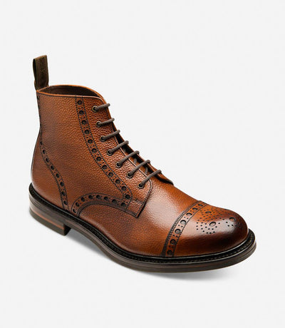 An angled shot capturing the dynamic lines and contours of the Loake Loxley Mahogany Derby Toe Cap Boots. The rich mahogany calf leather and intricate detailing are highlighted from this perspective, emphasizing the rugged sophistication of these boots.