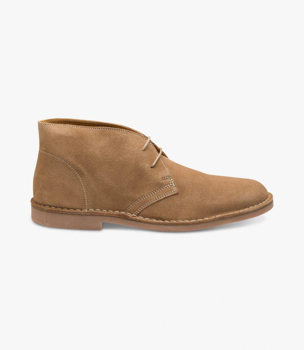 The side view of the Loake Sahara Tan Chukka Boot showcases its elegant silhouette, crafted from premium tan suede leather. The boot features a sleek profile with a rounded toe, highlighted by subtle stitching details that enhance its classic look. The stitched-down rubber sole provides a robust and durable base, ensuring excellent grip while adding to the boot’s refined appearance. The smooth finish of the suede adds depth and character, making it an eye-catching choice for both casual and formal occasions