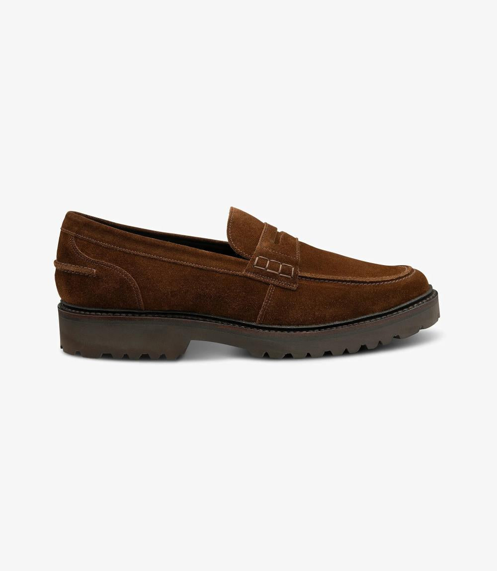  A sleek silhouette of the Loake Crux Brown Suede Loafer showcases its premium suede leather construction and contemporary design. The commando sole adds a rugged yet stylish touch, perfect for versatile wear.