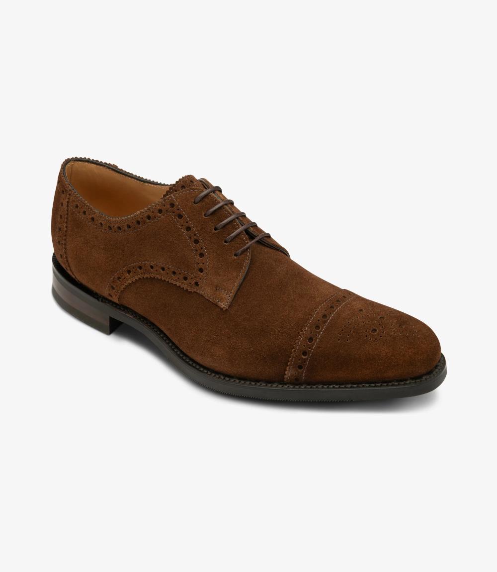 Captured from an angle, the outside profile of the Eldon reveals its exquisite craftsmanship and refined design, highlighting the velvety texture of the brown suede and the fine stitching, symbolizing timeless elegance and comfort.