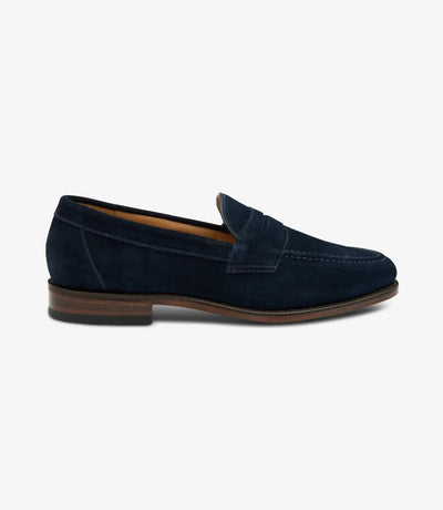 The outside profile of the Loake Imperial Navy Suede Loafer showcases its sleek silhouette, featuring a classic apron penny loafer design crafted from luxurious suede leather, exuding timeless elegance.