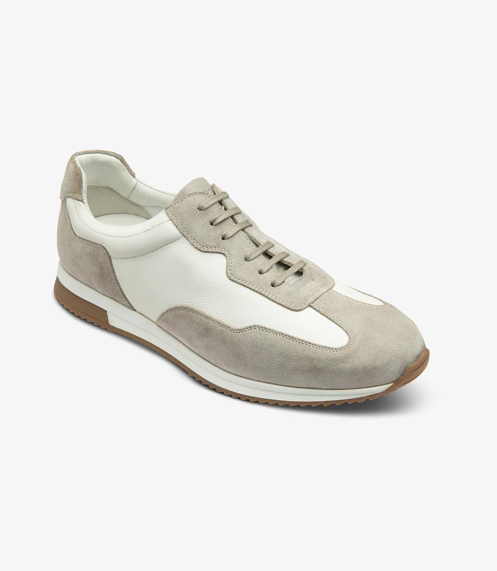 An angled shot of the Loake Linford White-Grey Leather Trainer, highlighting the elegant curves, the detailed stitching, and the contrast between the white and grey leather sections.