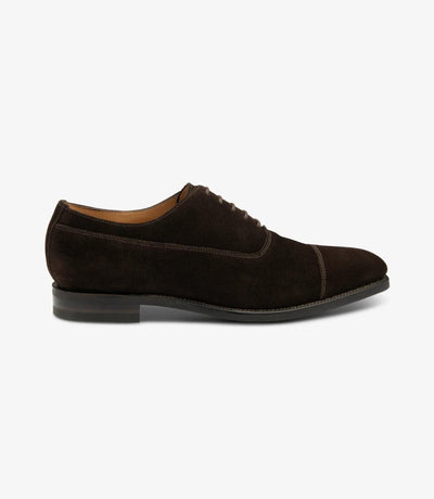 A sleek silhouette of the Loake Truman Dark Brown Suede Oxford showcases its luxurious suede leather exterior and refined Oxford design. The Goodyear welted shadow rubber sole adds durability and grip, perfect for both style and functionality.