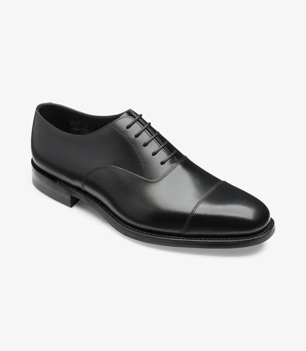 This angled shot captures the Loake Aldwych Oxford from a dynamic perspective. The curvature of the shoe is emphasized, showcasing the refined craftsmanship and attention to detail. The Toe Cap design is prominent, giving the shoe a distinguished look. The slight elevation of the heel adds a touch of formality, while the rubber sole is partially visible, hinting at both style and functionality.