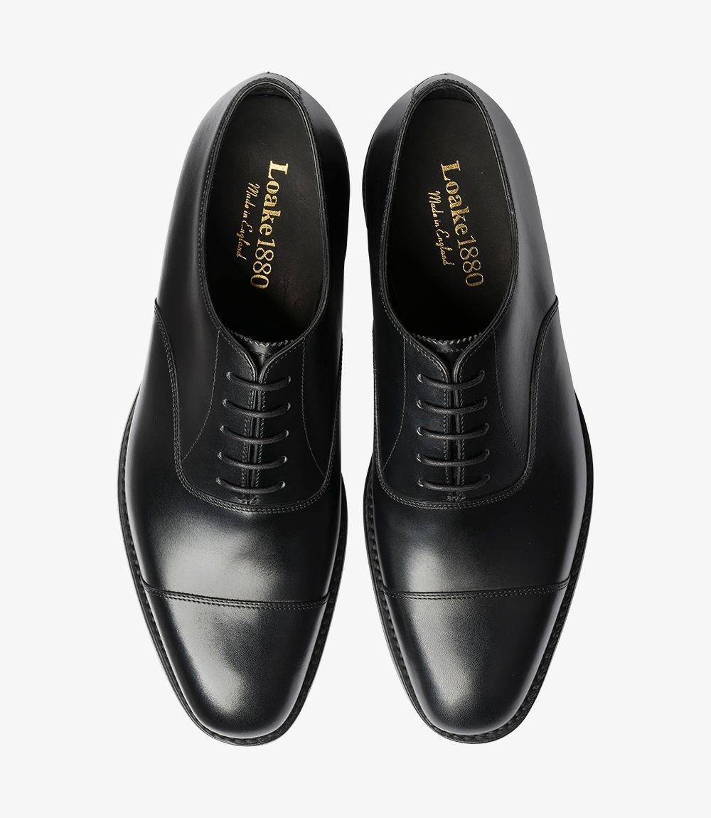 In this overhead view, the shoes are presented side by side, emphasizing their symmetry and design. The shiny black leather reflects light, accentuating the Toe Cap feature at the front. The laces are neatly tied, contributing to the overall polished appearance. This perspective also highlights the comfortable fit and sleek silhouette of the shoes, making them a versatile choice for any formal occasion.