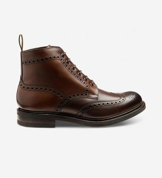 A captivating image showcasing the Loake Bedale Brogue Boots in Dark Brown, capturing their rugged elegance and superior craftsmanship. The burnished calf leather upper, adorned with classic brogue detailing, exudes timeless sophistication. Paired with Goodyear welted victory rubber soles, these boots are the epitome of durability and style. Perfect for both outdoor adventures and urban exploration, the Bedale Brogue Boots are a versatile and essential addition to any gentleman's wardrobe.
