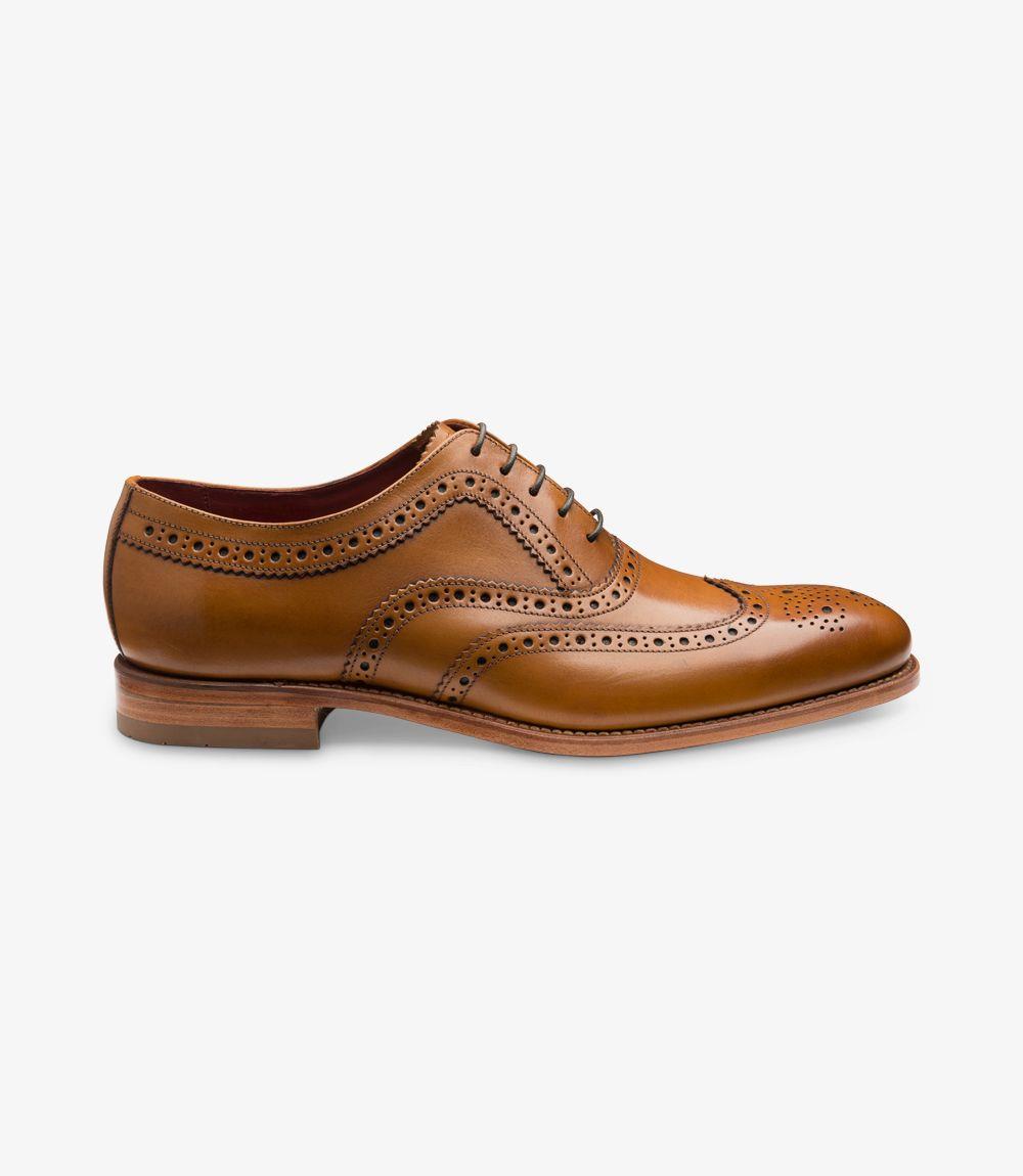 The side view of the Loake Fearnley Tan Oxford Brogue showcases its elegant silhouette and intricate brogue detailing. The smooth tan calf leather glistens subtly, highlighting the fine craftsmanship. The punched decorations along the quarter and toe add texture and sophistication to the shoe’s classic profile. The Goodyear welted sole is visible, indicating durability and quality, while the sleek lines and slightly elongated toe enhance its refined appearance.
