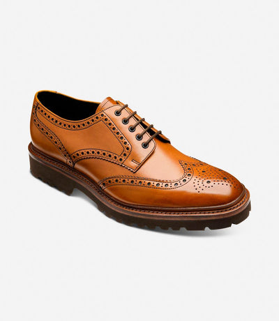 From a dynamic angle, the Perseus brogues reveal their meticulous craftsmanship and modern design. The rich tan calf leather gleams under the light, while the commando rubber sole provides traction and stability. The angled view accentuates the brogues' sophisticated profile and traditional charm.