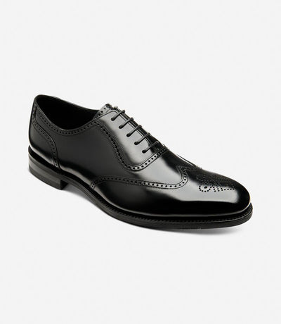 Captured at a dynamic angle, the Loake Tay Black Polished Oxford Semi-Brogue showcases its impeccable craftsmanship and attention to detail. The polished leather upper glistens under the light, while the semi-brogue design adds a touch of classic sophistication. The Goodyear welted shadow rubber sole provides stability and longevity, making it a versatile and stylish choice for any occasion.