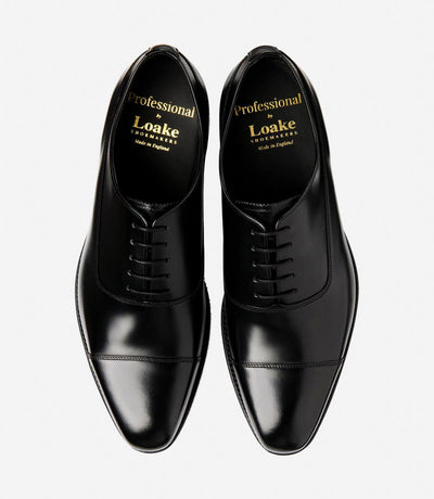 A bird's-eye view captures the symmetry and elegance of the Loake Truman Black Polished Oxford. The matching pair showcases the polished leather construction and sleek Oxford design. Perfectly crafted for formal occasions or professional attire, these shoes are a testament to classic style and superior craftsmanship.