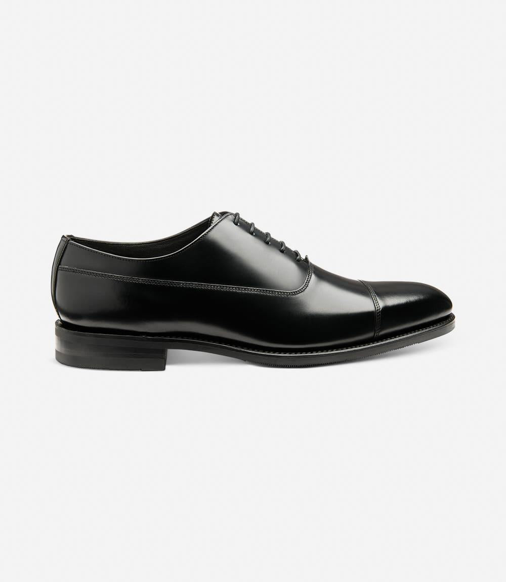 A sleek silhouette of the Loake Truman Black Polished Oxford showcases its polished leather exterior and refined Oxford design. The Goodyear welted shadow rubber sole adds durability and grip, perfect for both style and functionality.